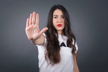 Gri arka planda duran güzel kadın..  