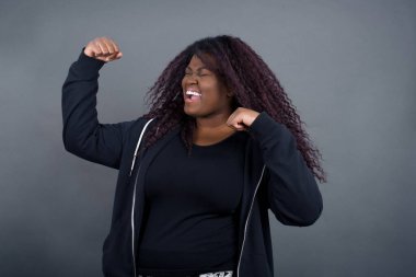 Sıradan kıyafetlerle, kollarını kaldırarak, yumruklarını sıkarak, neşe ve heyecanla golü haykırarak güçlü ve kararlı genç bir kadının portresi. Zafer, başarı ve başarı kavramı.