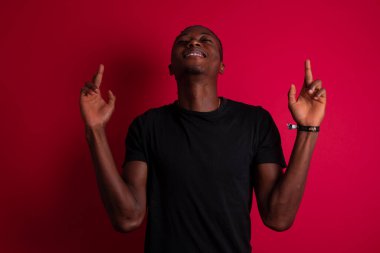 Kazanmak zorundayım. Neşeli Afrikalı Amerikalı adam dişlerini sıkar, parmaklarını çapraz yapar, arzulanan dilekleri yapar, yuvarlak gözlük takar ve günlük kıyafetler giyer, iyi haberleri bekler, duvarın arkasında durur.