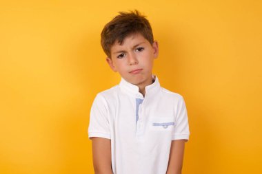 Yakışıklı çocuk sarı duvara karşı üzgün.  