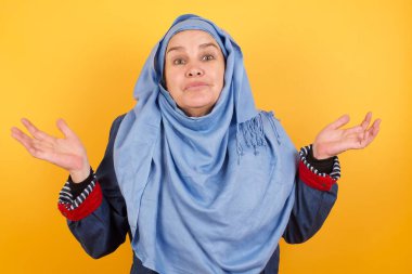 Belki evet ya da hayır. Şüpheli orta yaşlı, tesettürlü Müslüman kadın şaşkınlık içinde omuzlarını silker, bir karar vermeye çalışır..