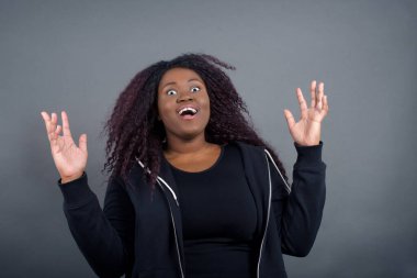 İnsanlar, başarı, galibiyet, zafer, heyecan, hedefler, kararlılık ve başarı konsepti. Neşeli, şanslı Afro-Amerikan kadın öğrenci günlük giysiler içinde tezahürat yapıyor, başarıyı kutluyor, evet diye bağırıyor. 