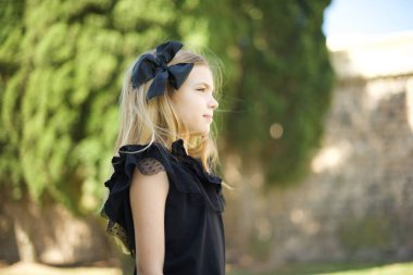 Sağlıklı, saf tenli, düşünceli, açık havada yürümeye hazır bir kızın profili.