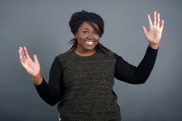 身穿休闲装的快乐的非洲裔美国女人做了一个受欢迎的手势 双手高举着头 与灰色背景隔离在一起 — 图库照片