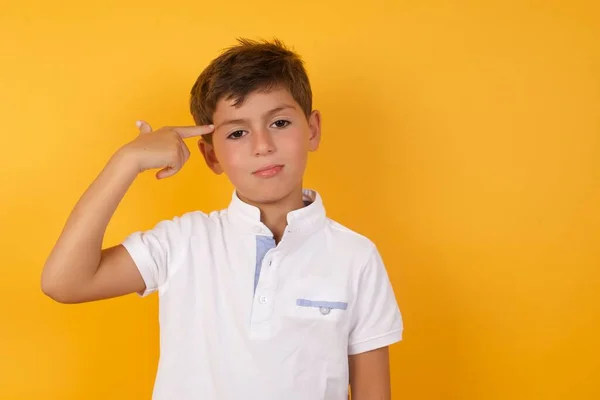 Schattig Jongen Met Pistool Gebaar Tegen Gele Muur — Stockfoto