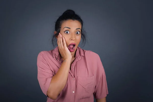 Surprise astonished beautiful girl. Closeup portrait woman looking surprised in full disbelief wide open mouth with hand near face. Positive emotion facial expression body language. Funny girl