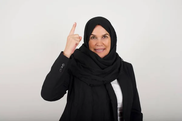 Zbliżenie Portret Uroczej Młodej Muzułmanki Czarnym Hidżabie Wskazując Palcem Górę — Zdjęcie stockowe