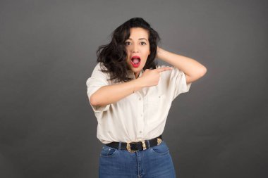 Gri arka planda gelişigüzel giyinmiş güzel esmer kadın..  