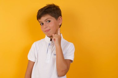 Yakışıklı çocuğun sarı duvara karşı bir fikri var.  
