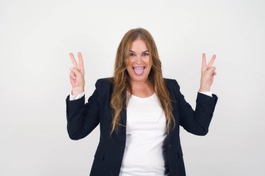 Gri arka planda izole edilmiş, iyimser bir gülüşü olan, iki eliyle barış ya da zafer hareketi gösteren orta yaşlı bir kadının kapalı portresi. Dostça görünüyor. V işareti.