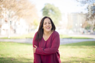 Parkta gülümseyen orta yaşlı güzel bir Arap kadın.  