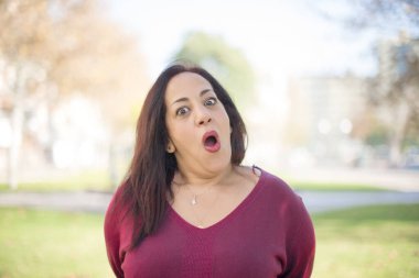 Parkta ağzı açık, orta yaşlı, güzel bir Arap kadın.  