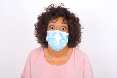 Yüz maskesi takan ve günlük kıyafet giyen kadın beyaz arka planda izole edilmiş.