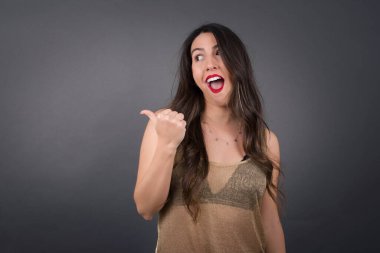 Gri arkaplanı işaret eden güzel kadın.  