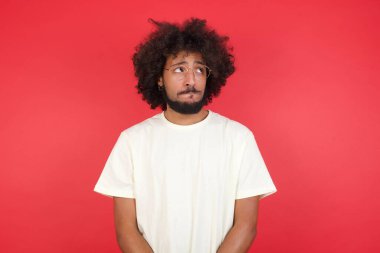 Kızıl duvara bakan afro saçlı genç adam. 