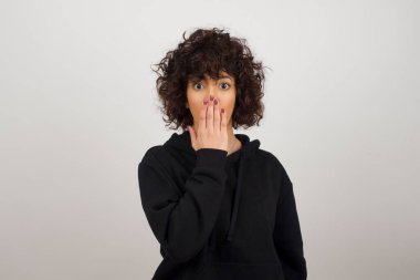 Avuç içiyle ağzını kapatan kadının portresini kapat. Büyük gözlerle kameraya bak. 