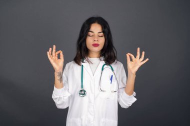 Hoş görünümlü genç doktor bayan öğrenci, düşünceli bir şekilde kenara bakıyor, işten sonra planlar yapıyor, ne yapacağını hayal ediyor. Zeki kadın yeni projesini düşünüyor. Boşluğu griye kopyala.