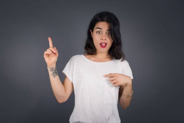 Pozitif mutlu kadın diyor ki: Vay be, ne kadar heyecan verici, hayret verici bir ifade, bir şey ifade ediyor. Neşeli genç bayan bir şeyler gösteriyor. Bir eli göğsünde ve diğer eliyle işaret ediyor..