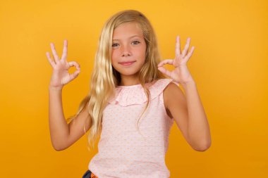 Sarışın, tatlı küçük kız sarı stüdyo geçmişine karşı iyi görünüyor. 