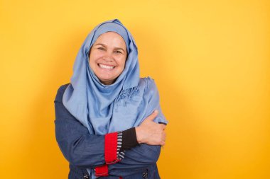 Utangaç, orta yaşlı, tesettürlü Müslüman kadın kendini mutlu hissediyor. 