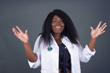 Başarı, başarı konsepti. Neşeli Afrikalı Amerikalı kadın doktor ellerini kaldırıyor, mutluluk dolu gözleriyle büyük başarılarını kutluyor.. 