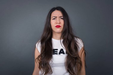 Güzel kadın, gri arka planda üzgün..  