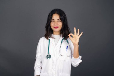 Meditasyon, din ve ruhani uygulamalar. Güzel genç doktor kadın sabah işe gitmeden önce yoga yapıyor, gözlerini kapalı tutuyor, Mudra jestinde parmaklarını tutuyor..