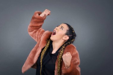 Sıradan kıyafetlerle, kollarını kaldırarak, yumruklarını sıkarak, neşe ve heyecanla golü haykırarak güçlü ve kararlı genç bir kadının portresi. Zafer, başarı ve başarı kavramı.