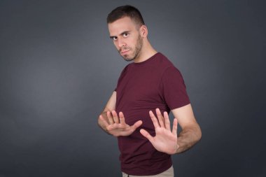 Tecrit edilmiş, korku ve korkudan dehşete düşmüş yakışıklı genç adam ve tiksindirici ifade iki elinle hareket etmeyi kes ve orada kal de. Panik konsepti