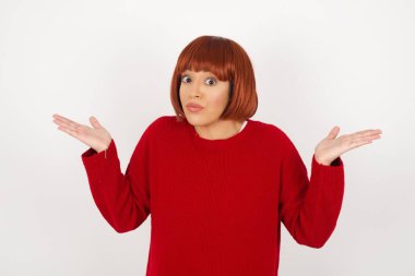 Kafası karışmış, kolları açık genç bir kadın omuzlarını silkip 