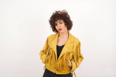 Süet ceketli güzel bir kadın stüdyo pozu veriyor.