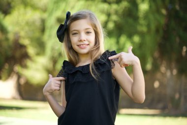 Siyah elbiseli, çekici, duygusal, beyaz, tatlı bir kız. Pozitif duygularını gösteriyor. 