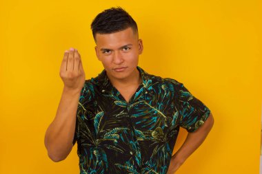 What the hell are you talking about. Shot of frustrated young hispanic man gesturing with raised hand doing Italian gesture, frowning, being displeased and confused with dumb question.