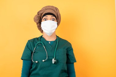 Emotive genç, güzel, Müslüman doktor kadın yeşil üniformalı, yıldönümünü kutlamak için mutlu ve heyecanlı. Mutlu genç bayanın keyfi yerinde..