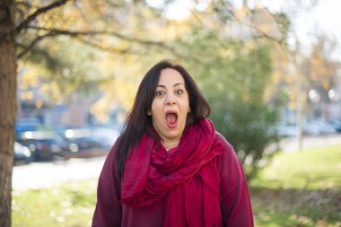 Parkta ağzı açık, orta yaşlı, güzel bir Arap kadın.  