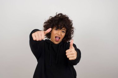 Sarışın genç bir kadın, izole edilmiş arka planda. Elleriyle olumlu jest yapıyor. Gülümsüyor ve mutlu. 