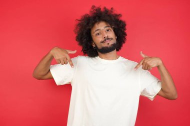 Kızıl duvarda siyah saçlı genç bir adam.   