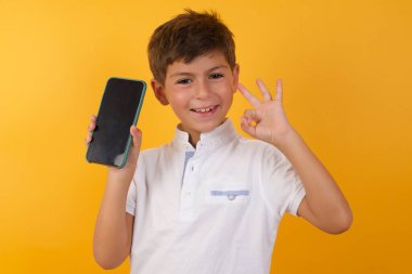 Akıllı telefon sarı duvarda iyi görünüyor.  