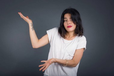 Güzel Avrupalı bir kız iki eliyle tuhaf bir şey gösterip 