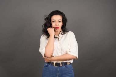 Gri arka planda gelişigüzel giyinmiş güzel esmer kadın..  