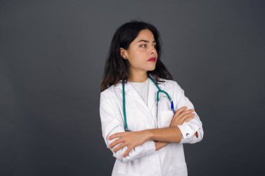 İçeride kollarını kavuşturmuş, üzgün, genç, beyaz bir doktorun görüntüsü. Kötü haberleri dinledikten sonra hayal kırıklığına uğramış bir ifadeyle bakıyorum. Kendine güvenen kız..