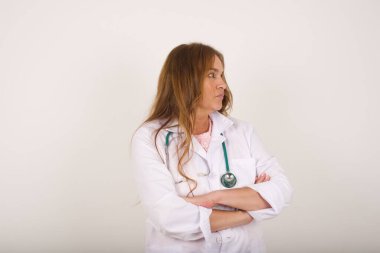 İçeride kolları kavuşturulmuş, üzgün, genç bir doktorun görüntüsü. Kötü haberleri dinledikten sonra hayal kırıklığına uğramış bir ifadeyle bakıyorum. Kendine güvenen kız..