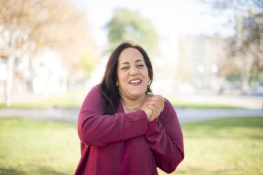 Parkta gülümseyen orta yaşlı güzel bir Arap kadın.  