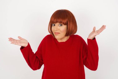 Belki evet ya da hayır. Modaya uygun olmayan bir kız şaşkınlık içinde omuz silkiyor, karar vermeye çalışıyor. Beyaz beton duvarın üzerinden neyi izole etmek istediğini şaşırtıyor. Tereddüt ve belirsizlik.