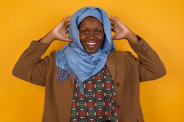 Heyecanlı Afrikalı Amerikalı Müslüman kadın iyi haberler aldıktan sonra çığlık atıyor, ellerini başının üstünde tutuyor, buna inanamıyorum..