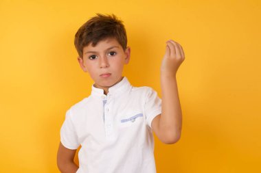 Sarı duvara yaslanan sevimli çocuk.  