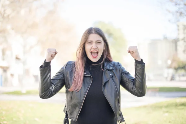 young beautiful woman with  fists   in the park