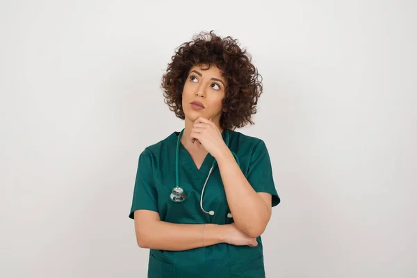 Düşünceli gülümseyen doktor kızın portresi elini çenesinin altında tutuyor, yan bakıyor, ilgi çekici bir şey düşünüyor. Karar alma kavramı.