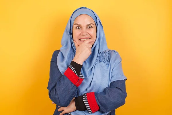 彼女の手で彼女の口を覆い 屋内で立っているヒジャブの美しい中年のイスラム教徒の女性の概念的なイメージ — ストック写真