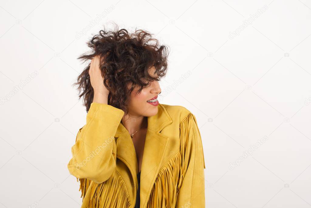 Shot of happy young woman with positive smile, has long hair, rejoices having weekend and good rest after hard working exhausting week, isolated on gray wall.